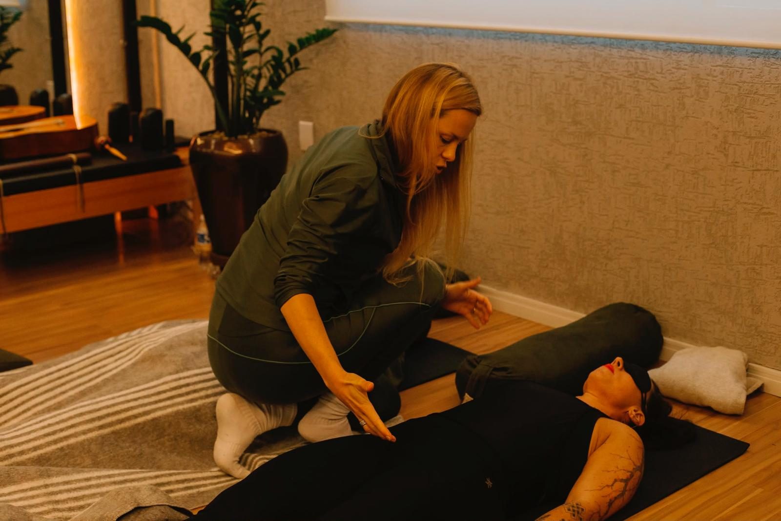 Karina working hands-on with a participant lying down during a somatic session